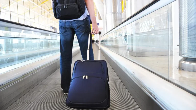 Reisender geht mit Koffer am Flughafen