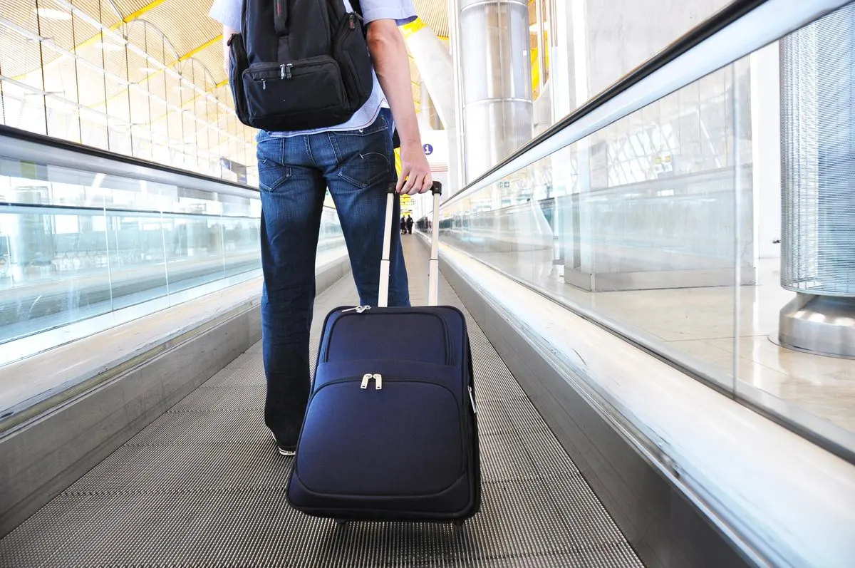 Reisender geht mit Koffer am Flughafen