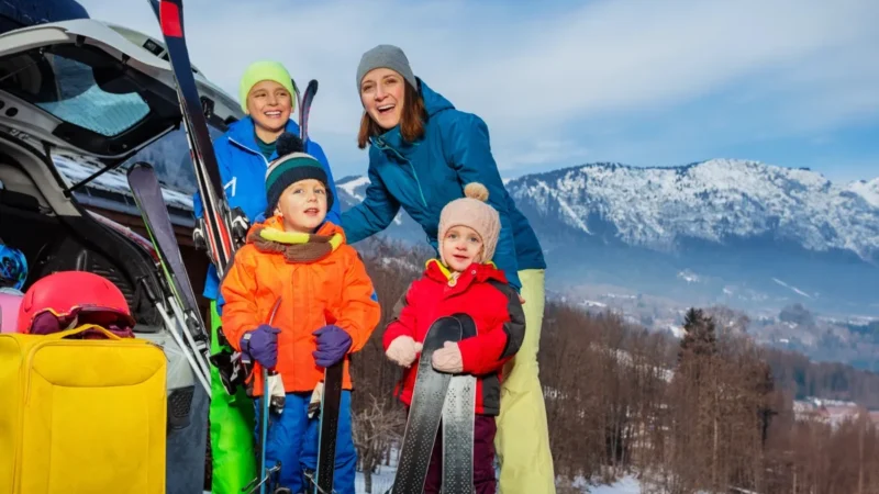 Familie mit Ski am offenen Kofferraum, für den Transport im Auto oder Flugzeug schützt eine Skitasche die Ausrüstung